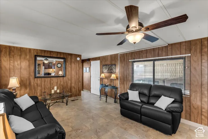 Wood-paneled walls, tile flooring, and a ceiling-mounted light fixture with a fan