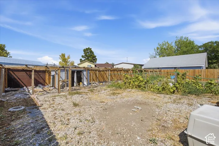 Fenced backyard featuring wood-framed structural enclosures and perimeter wood fencing