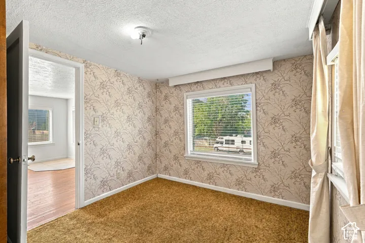 Wall-to-wall carpeting and floral-patterned wallpaper