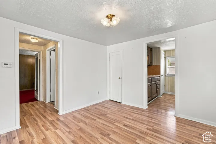 Wood-finish flooring throughout, white painted walls, and a ceiling-mounted light fixture