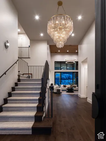 Grand entryway featuring a multi-tiered chandelier, recessed lighting, and dark wood-finish flooring