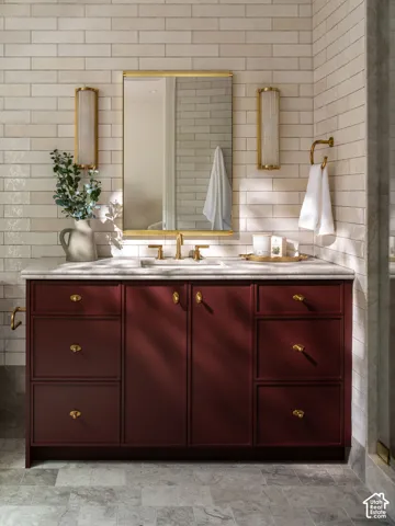 Redwood-finish vanity with gold-tone hardware, a white countertop, and integrated sink