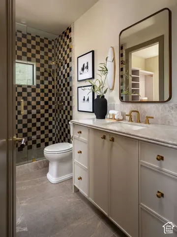 Shower featuring a checkered tile surround with gold-finish hardware, a glass enclosure, and a built-in window