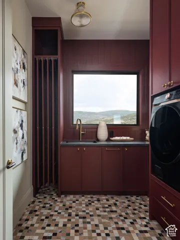 Built-in cabinetry with gold-tone hardware, sink with a gold-tone faucet, tiled backsplash, and multi-tone square-tiled flooring