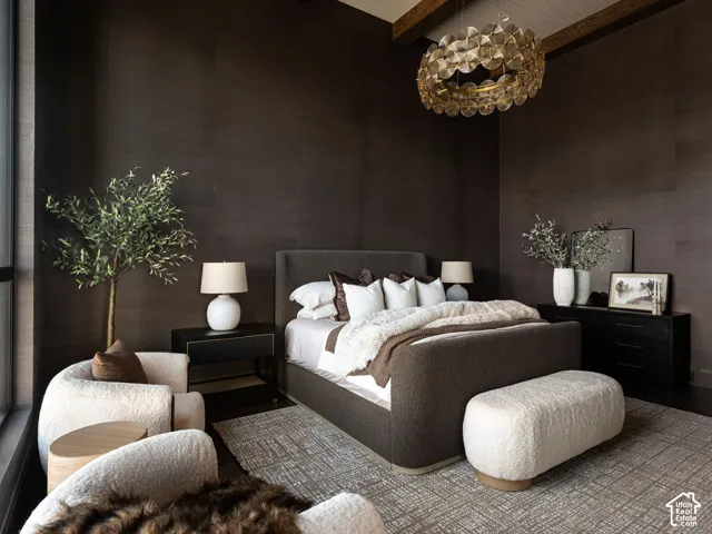 Dark-toned walls, vaulted ceiling with exposed wood beams, and a distinctive circular chandelier