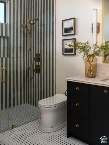 Walk-in shower with vertical stripe wall tile and brass fixtures