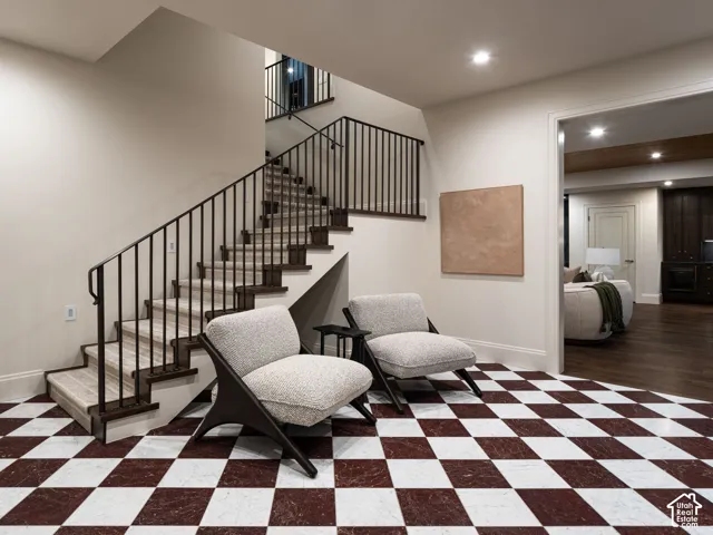 Checkered tile flooring, staircase with wood-finish treads, iron balusters, recessed lighting, and crown molding