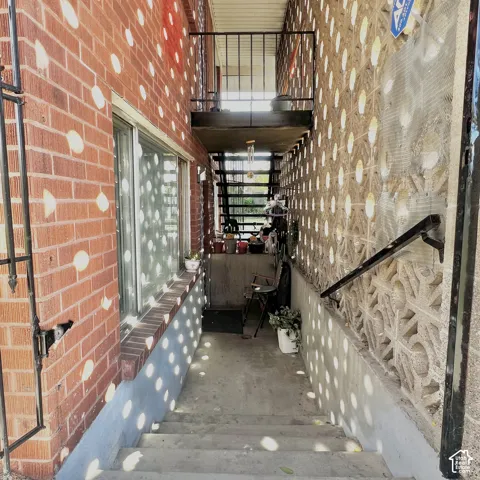 Exterior stairwell featuring red brick masonry, decorative concrete screen walling, and metal railing