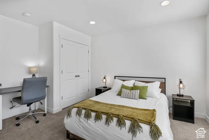 Neutral-toned carpeting, recessed ceiling lighting, and a double-door closet with brushed nickel hardware