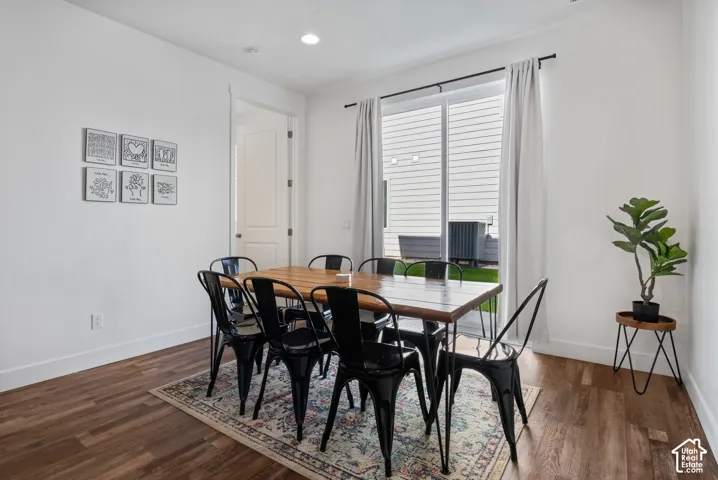 Wood-finish flooring, recessed ceiling lighting, and a sliding glass door with a metal curtain rod