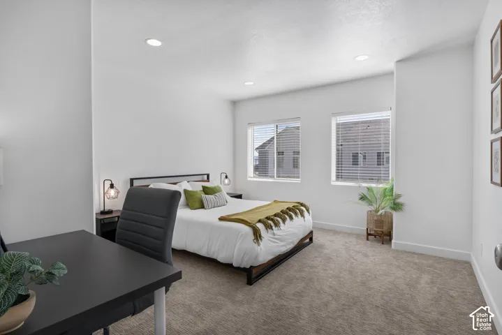 Neutral-toned carpeting, recessed ceiling lighting, and dual windows