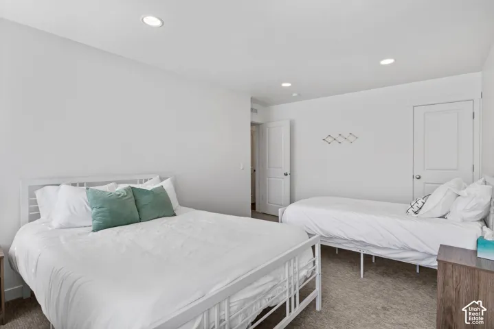 Interior room featuring neutral wall-to-wall carpeting, recessed ceiling lighting, and two-panel solid core doors