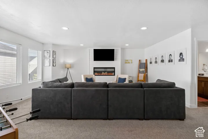 Linear electric fireplace, floor-to-ceiling shiplap surround, recessed lighting, and expansive windows