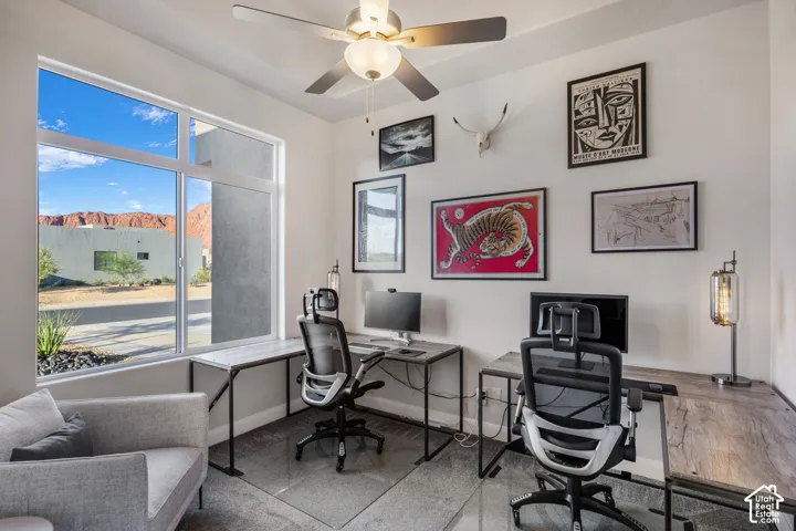 Room featuring a ceiling fan with integrated lighting, large picture window with mountain backdrop, and neutral wall tones