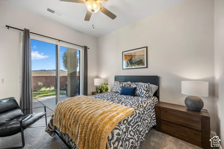 Room featuring neutral carpeting, a ceiling fan with integrated lighting, and a sliding glass door providing external access to a concrete patio
