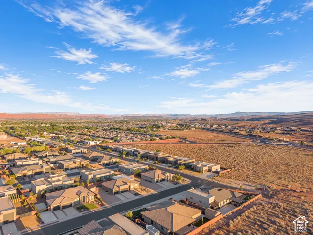 Aerial perspective of a residential neighborhood featuring mountain topography and natural desert terrain