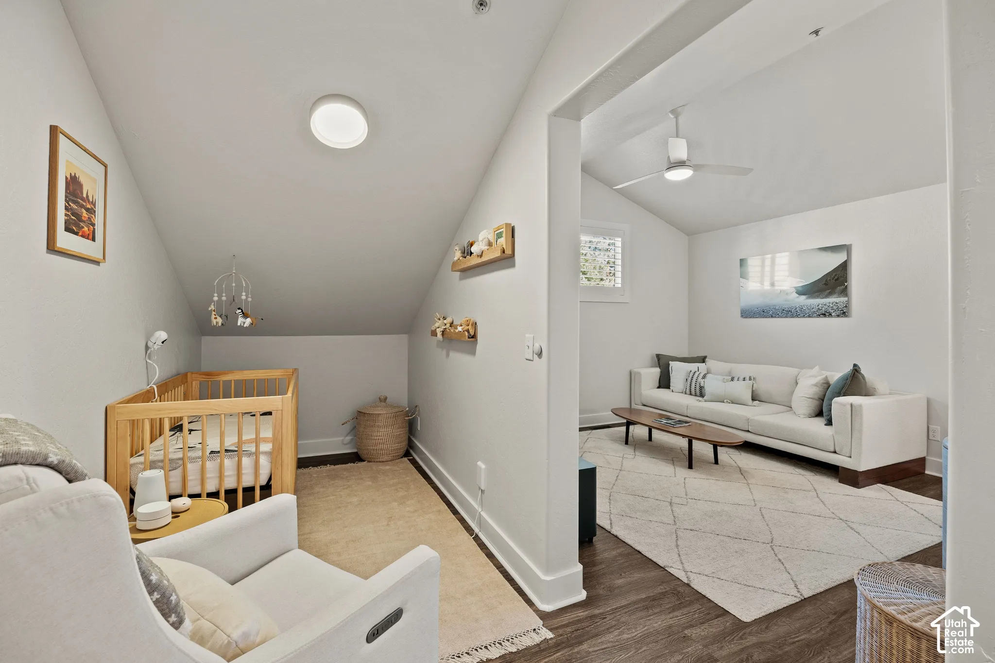 Attic room with angled ceiling and recessed lighting, featuring wood-finish flooring