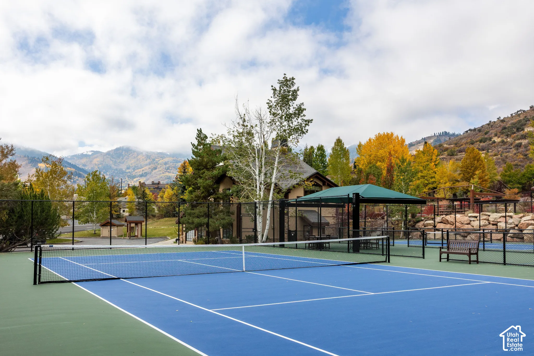 Blue and green surfaced tennis court with a black net