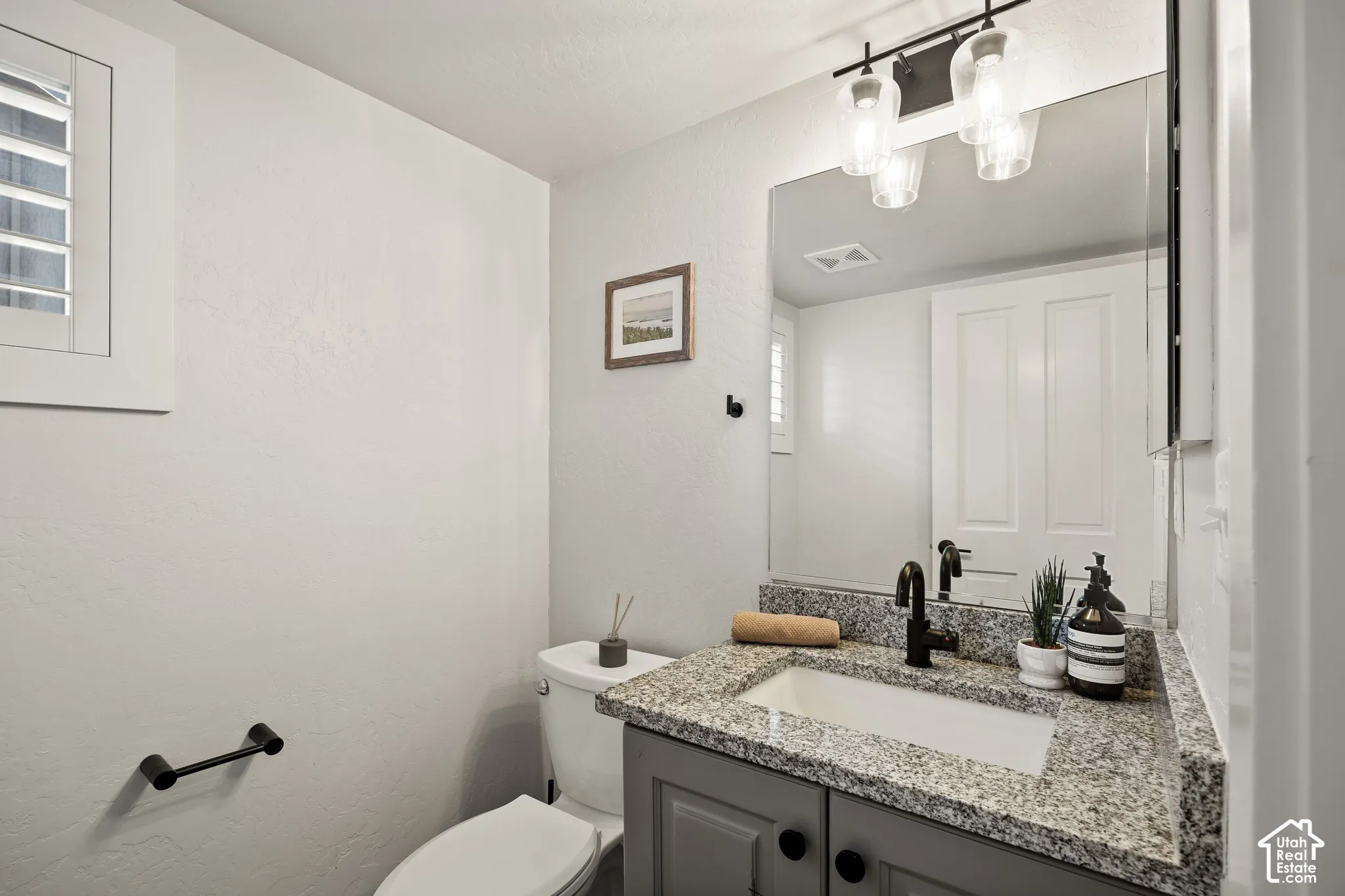Granite-finish countertop with an integrated sink, dark cabinet vanity, and a matte black faucet