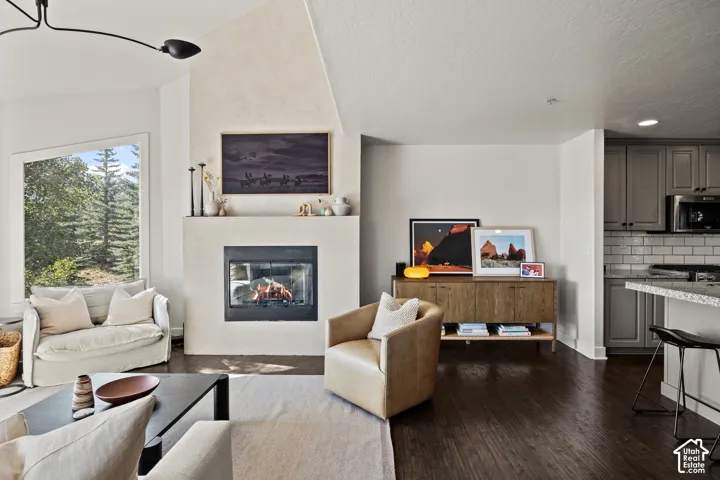 Living area with a built-in fireplace, sloped ceiling, and large window