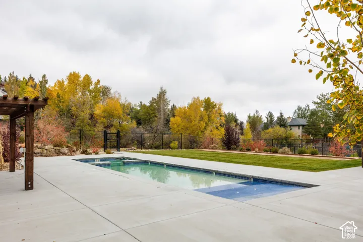 Rectangular swimming pool with integrated spa, surrounded by a concrete patio