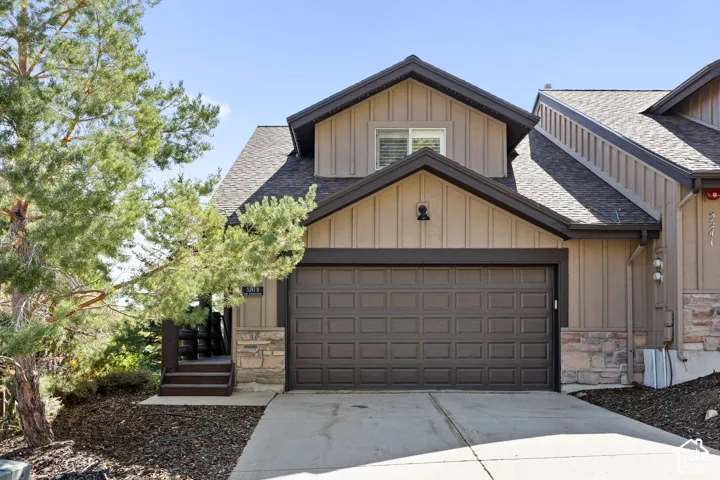 Brown paneled garage door with concrete driveway