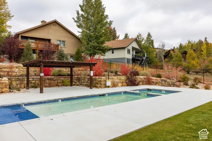 Outdoor swimming pool with integrated spa and surrounding concrete decking