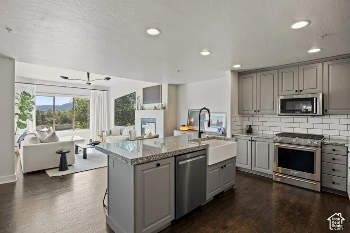 Kitchen with shaker-style cabinetry, granite island countertop, and a farmhouse sink