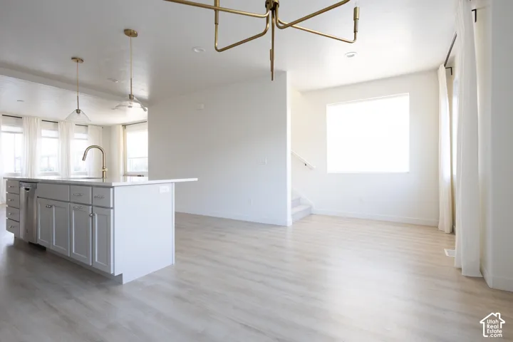 Kitchen featuring a central island with white cabinetry, wood-finish flooring, recessed lighting, and a multi-arm geometric pendant fixture