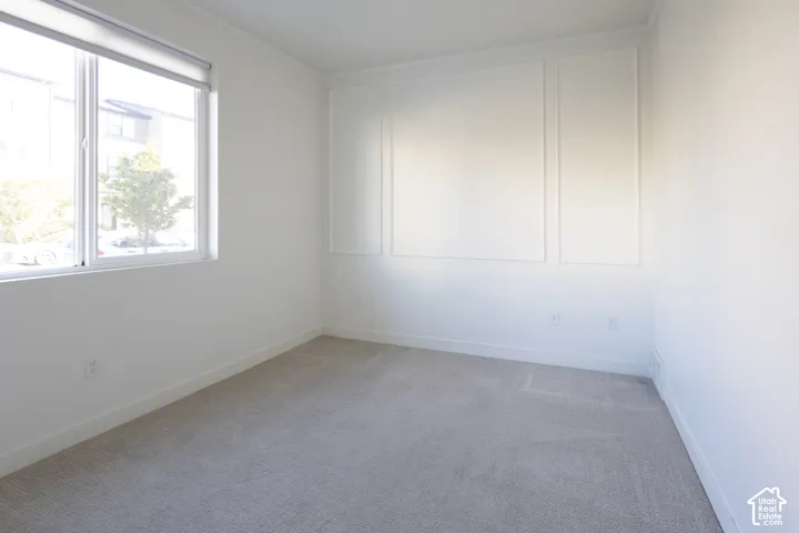 Interior space featuring wall panel molding, wall-to-wall carpeting, and a dual-pane window with an integrated blind