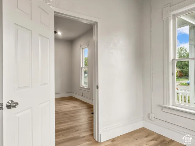 Wood-finish flooring, multi-pane windows with decorative casing, and classic interior doors with metallic hardware