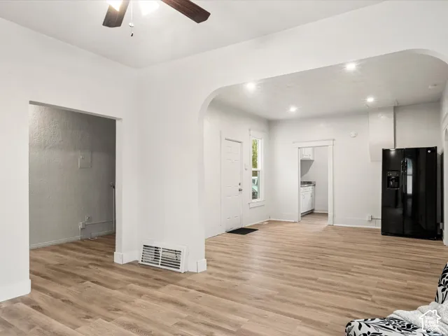 Open-concept interior featuring archway architectural detailing, wood-finish flooring, recessed lighting, and a ceiling fan