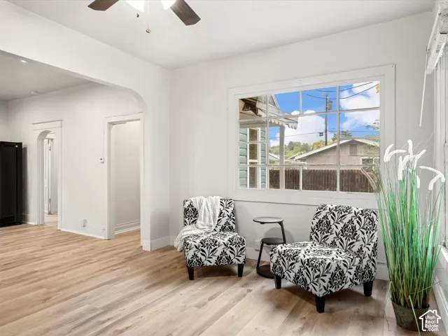 Interior space featuring wood-finish flooring, a multi-pane grid window, and arched architectural doorways