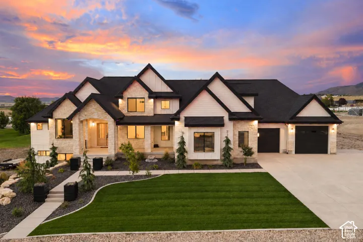 Striking Tudor-inspired residence showcasing stucco and dark timber exterior detailing, multiple peaked rooflines with architectural depth, and substantial dual-bay garage