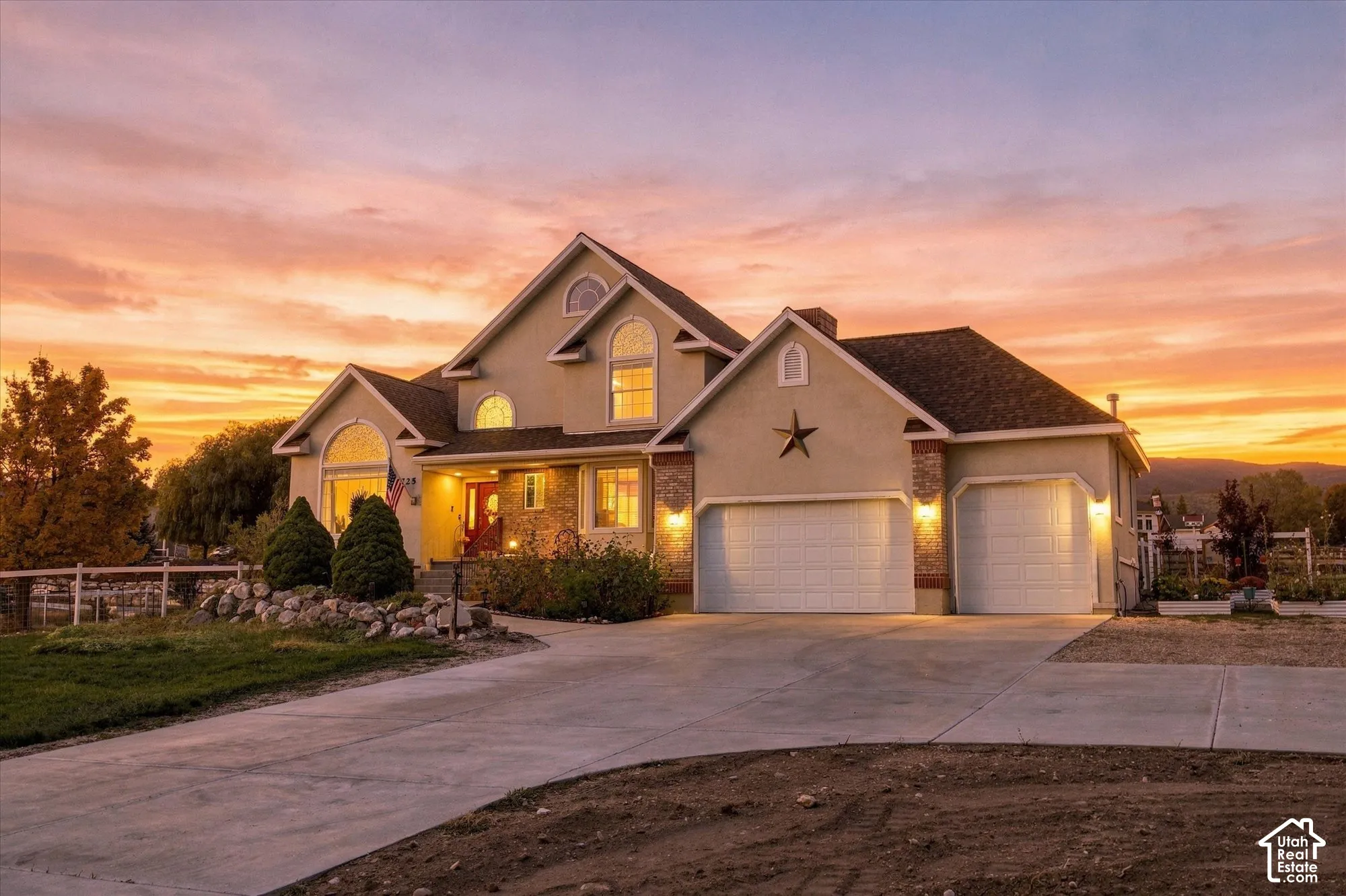 Multi-level stucco exterior featuring stone veneer accents, multi-gabled rooflines, arched window detailing, and an attached three-car garage