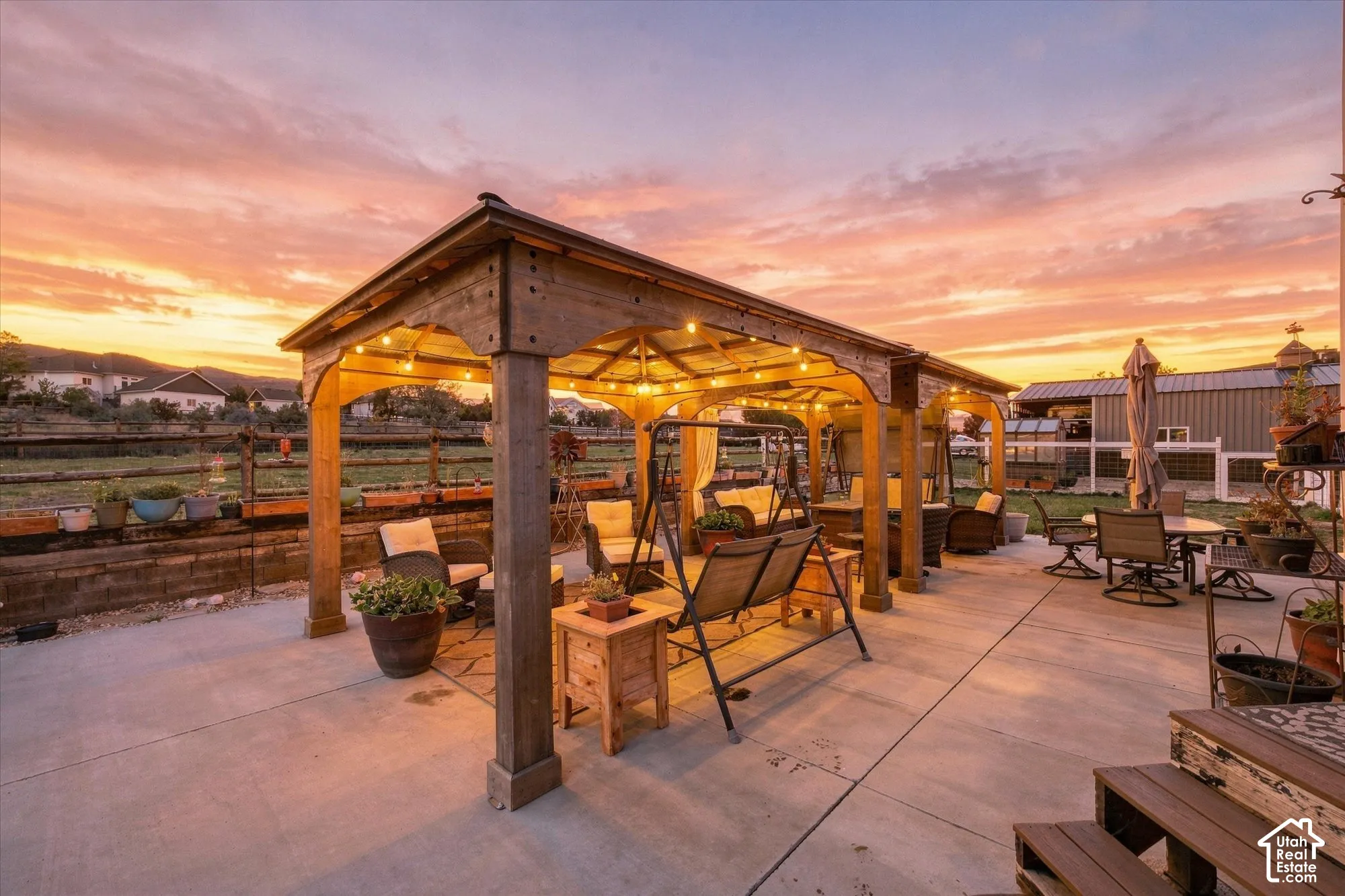 Concrete patio featuring a large timber-framed pergola, retaining wall with integrated planter boxes, and mountain backdrop