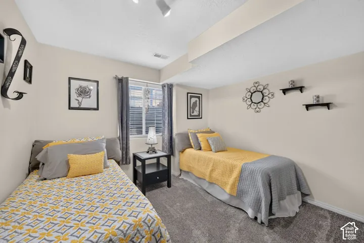 Neutral wall tones, wall-to-wall carpeting, and a dual-pane window with adjustable window treatments