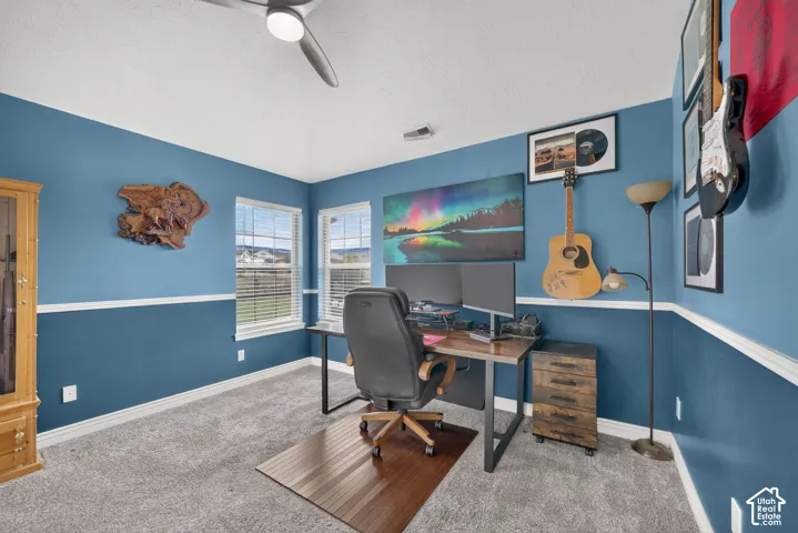 Room featuring high tray ceilings, two-tone wall paint, a chair rail, and dual windows with blinds