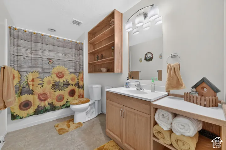 Bathroom featuring a wood-finish vanity with an integrated basin, wall-mounted wood shelving unit, recessed mirror, and multi-light vanity fixture