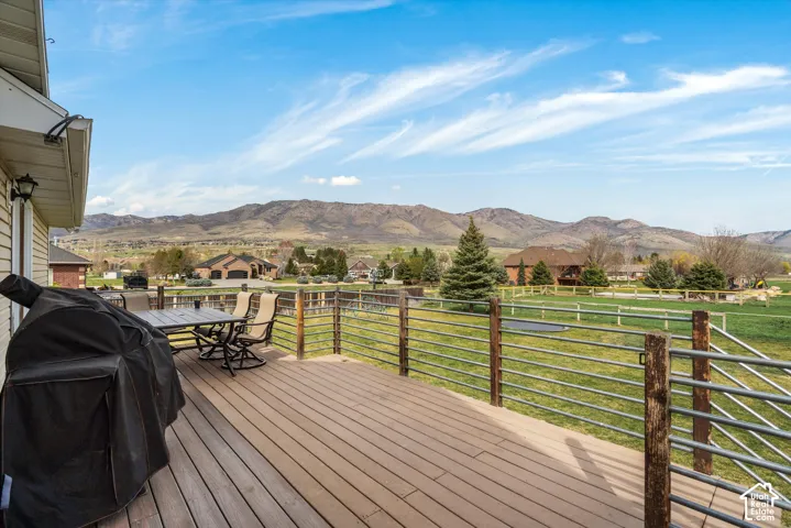 Elevated deck featuring composite decking, metal railings with wood posts, and an expansive mountain backdrop