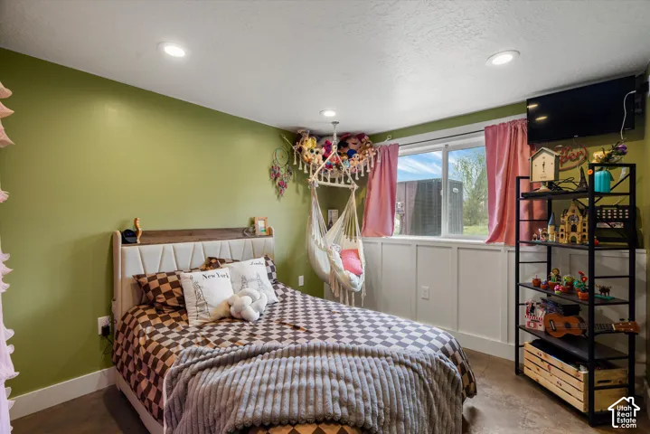 Room interior featuring board and batten wall paneling, recessed lighting, and a large slider window