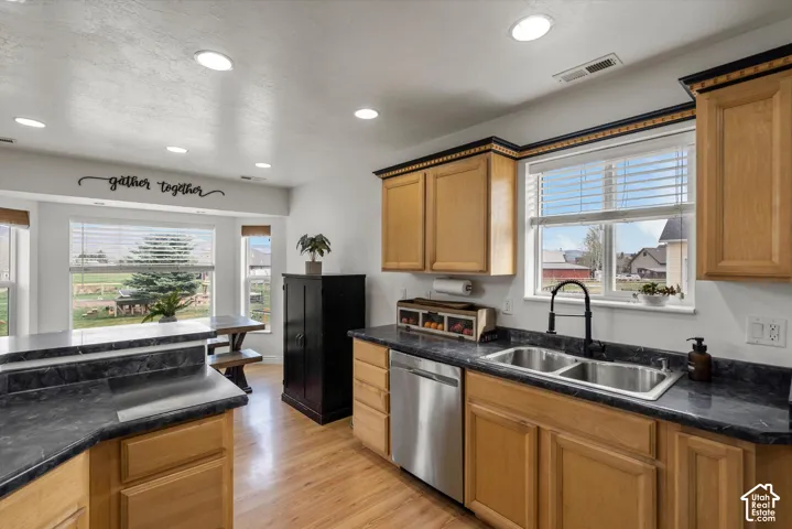 Kitchen featuring recessed lighting, wood cabinetry, dark stone-finish countertops, stainless steel dishwasher, and wood-finish flooring