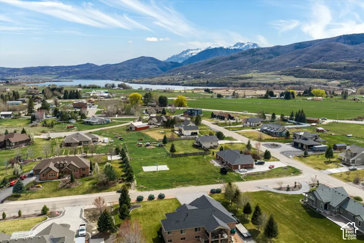 Aerial perspective of the residential area featuring sprawling green space, paved roadways, and mountain range backdrop