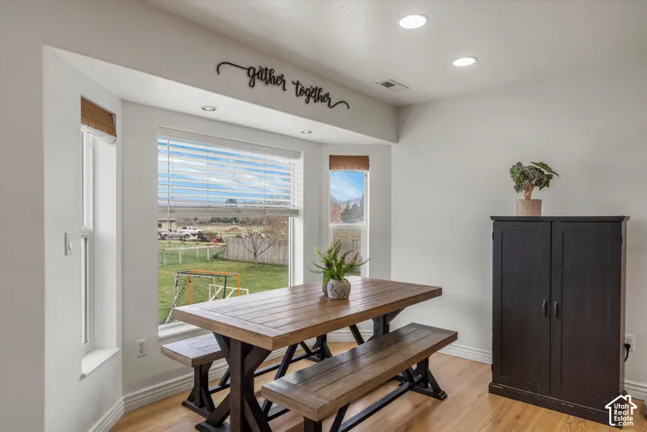 Bay window featuring three paneled windows, inset recessed lighting, and light-toned wood-finish flooring