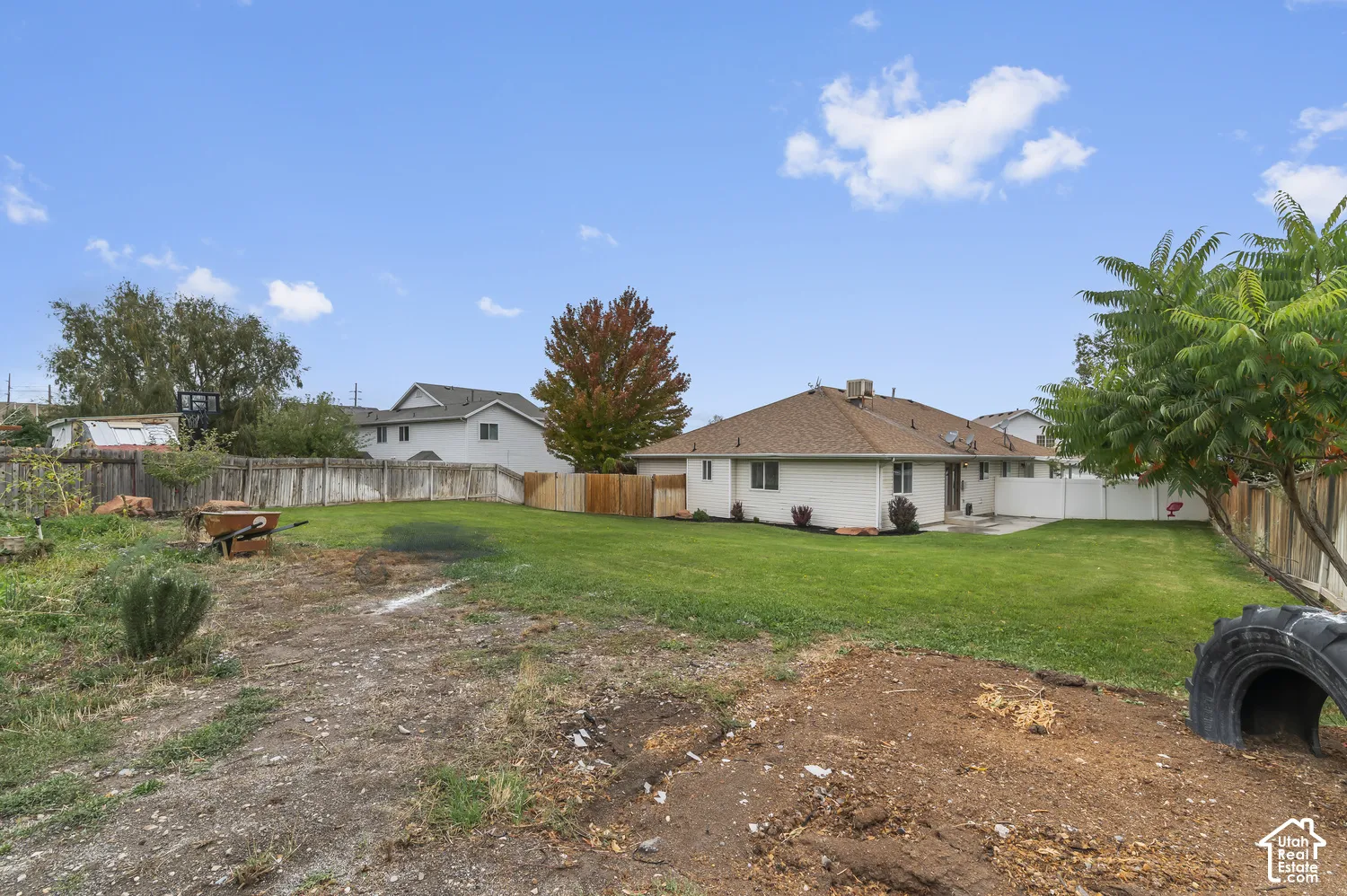 Expansive backyard featuring a large grass lawn and perimeter wood fencing