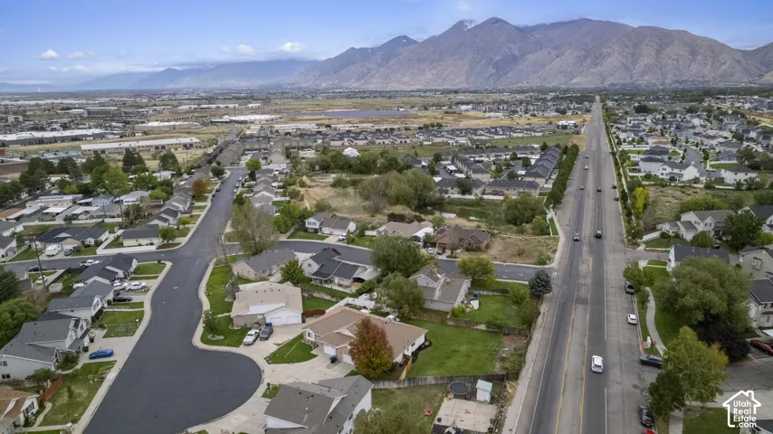 Aerial perspective featuring an expansive mountain backdrop and established residential neighborhood with mature trees