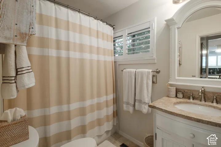 White vanity with a stone countertop and undermount sink