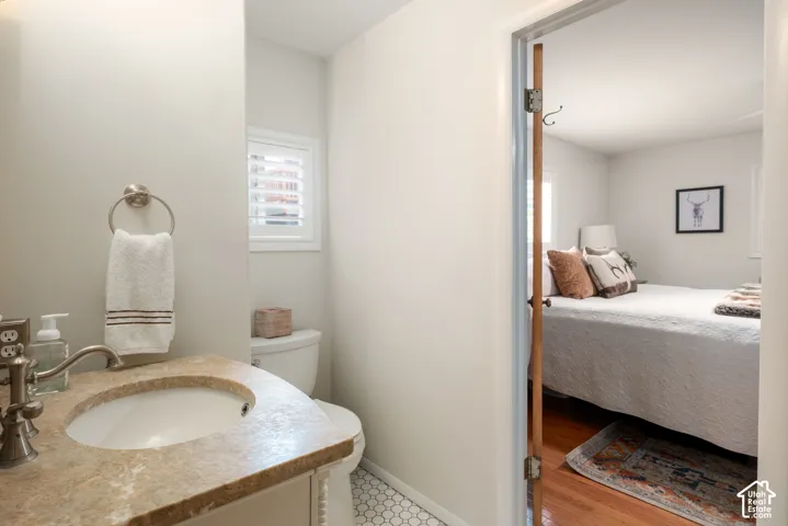 Compact bathroom featuring a vanity with an integrated sink, stone countertop, and brushed nickel faucet