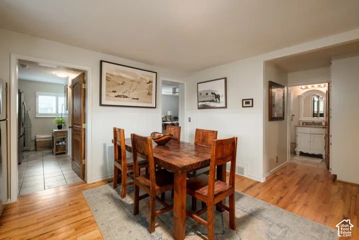 Hardwood flooring, white wainscoting, and a solid wood door