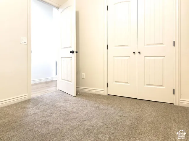 Neutral carpeting, solid-core interior doors with arched paneling, and double-door closet entry